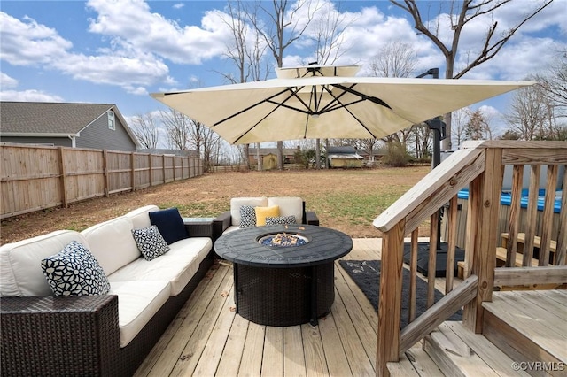 deck with an outdoor living space with a fire pit and a fenced backyard