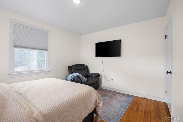 bedroom with baseboards and wood finished floors