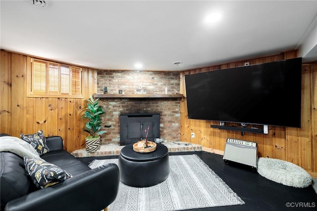 living area with a brick fireplace and wood walls