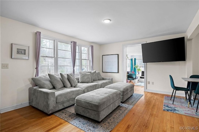 living area featuring light wood-type flooring and baseboards