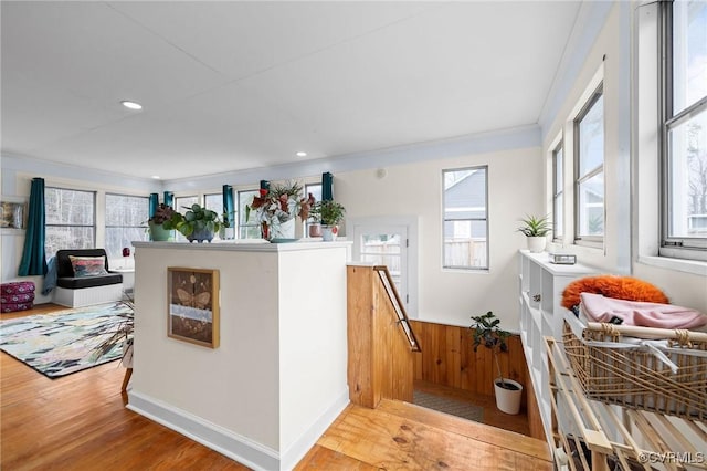 interior space with open floor plan, recessed lighting, crown molding, and wood finished floors