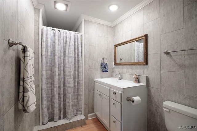 bathroom with vanity, crown molding, curtained shower, tile walls, and toilet