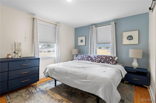 bedroom featuring wood finished floors and baseboards