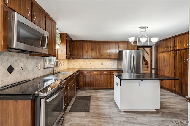 kitchen with a sink, decorative backsplash, hanging light fixtures, appliances with stainless steel finishes, and dark countertops