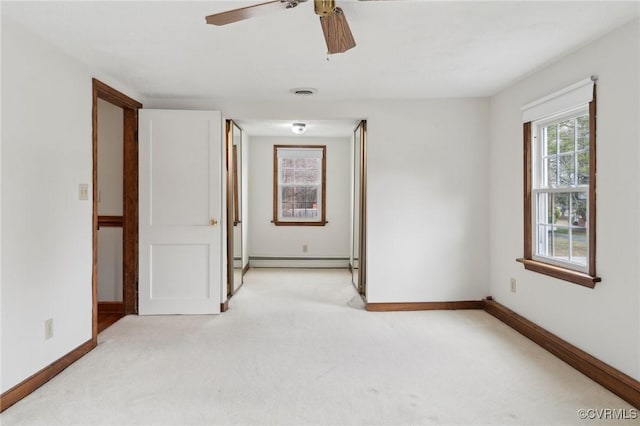 unfurnished room with light carpet, baseboards, a baseboard heating unit, and a ceiling fan