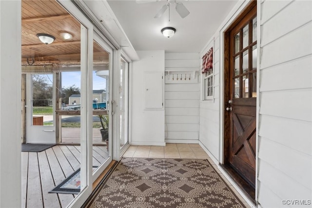 doorway with tile patterned flooring and a ceiling fan