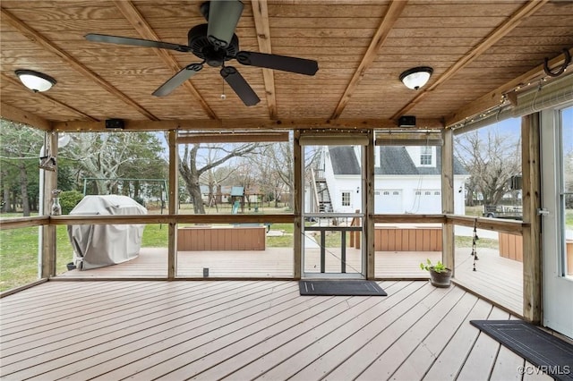 unfurnished sunroom with a healthy amount of sunlight, wood ceiling, and a ceiling fan