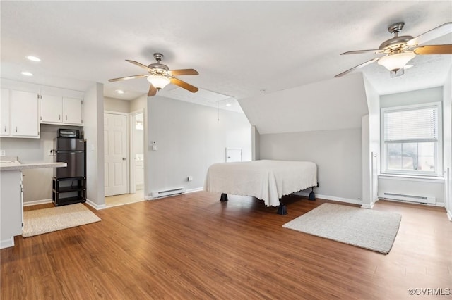 unfurnished bedroom featuring wood finished floors, attic access, and a baseboard radiator