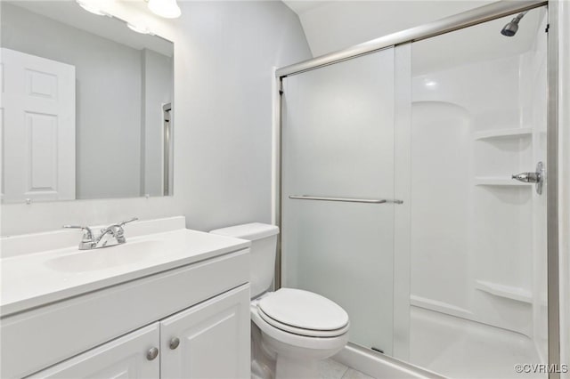 bathroom featuring vanity, toilet, and a stall shower