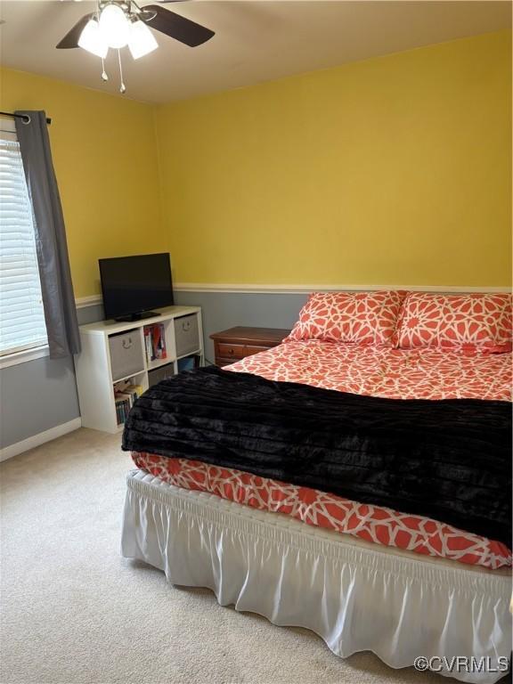 carpeted bedroom with baseboards and a ceiling fan