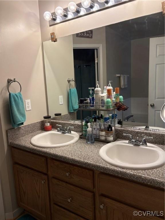 bathroom featuring double vanity, a bath, and a sink