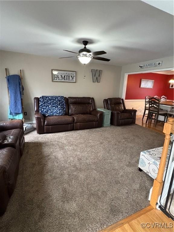 living area with wood finished floors and a ceiling fan