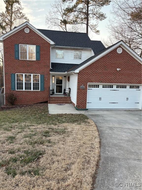 traditional-style house featuring brick siding, an attached garage, a front lawn, roof with shingles, and driveway