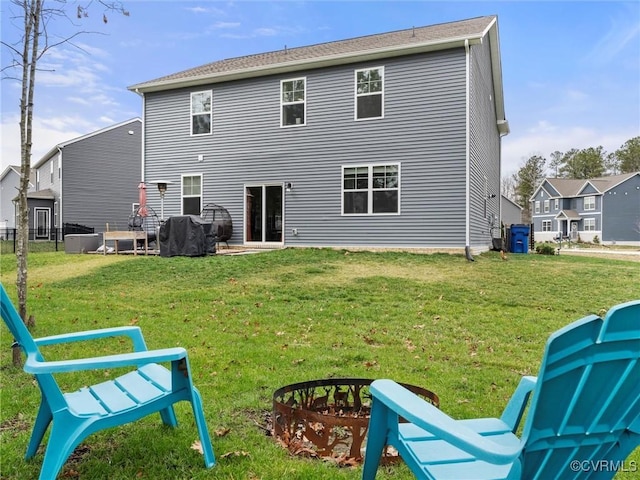 rear view of house featuring a lawn and fence