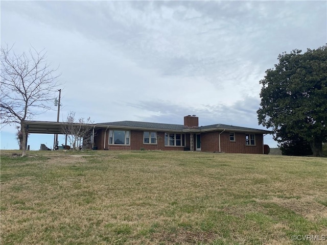 ranch-style home with brick siding, a front lawn, an attached carport, and a chimney