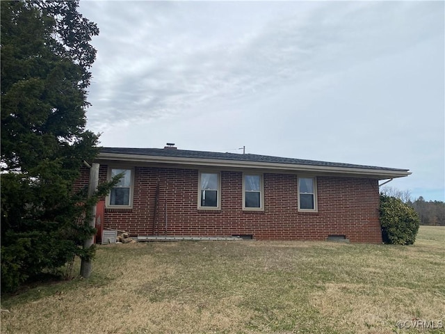 back of house featuring a yard and brick siding