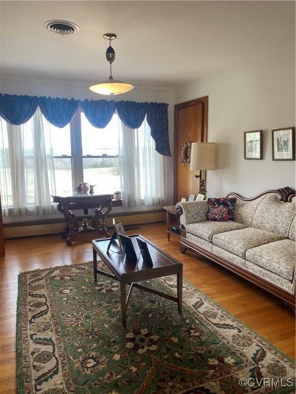 living area with visible vents and wood finished floors