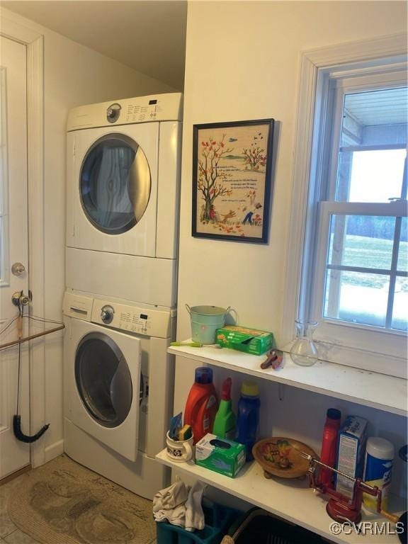 clothes washing area with stacked washer / dryer and laundry area