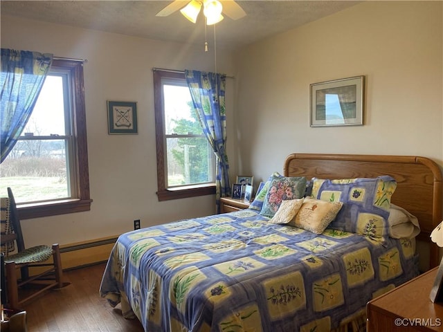 bedroom featuring ceiling fan, multiple windows, and hardwood / wood-style floors