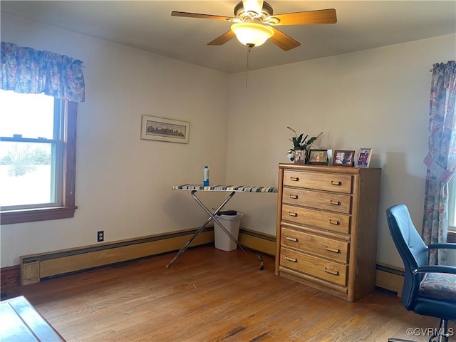 interior space with light wood-style floors, baseboard heating, and ceiling fan