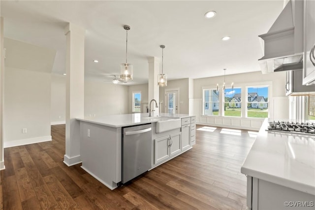 kitchen with custom exhaust hood, appliances with stainless steel finishes, light countertops, and a sink