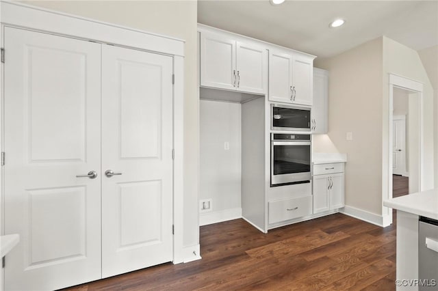 kitchen featuring dark wood finished floors, light countertops, recessed lighting, appliances with stainless steel finishes, and white cabinetry