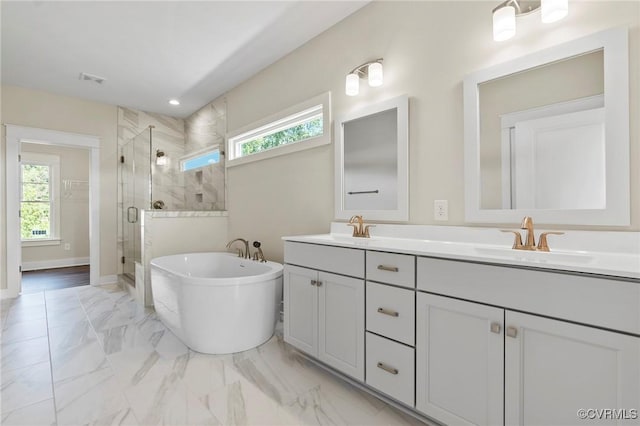 bathroom with marble finish floor, a wealth of natural light, and a sink