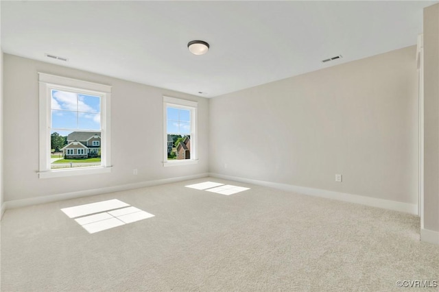 unfurnished room with visible vents, baseboards, and carpet