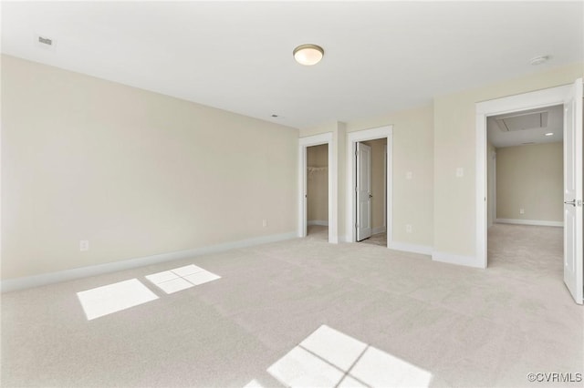 unfurnished bedroom featuring baseboards, light colored carpet, and a spacious closet