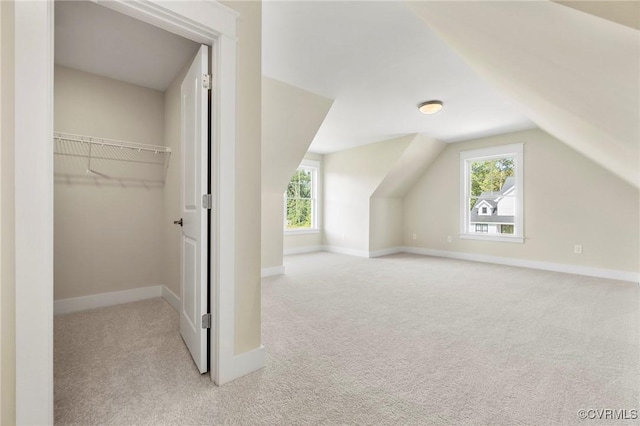 additional living space with baseboards, carpet floors, and vaulted ceiling