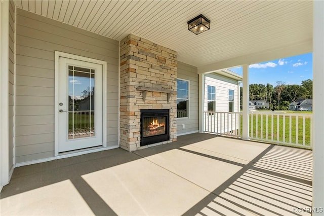 view of patio / terrace featuring a porch and an outdoor stone fireplace