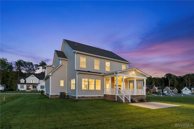 back of house featuring crawl space, central air condition unit, a lawn, and covered porch