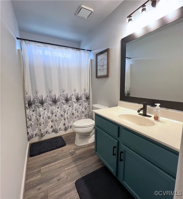 full bath featuring vanity, a shower with curtain, wood finished floors, visible vents, and toilet