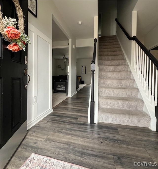 entryway featuring stairway, wood finished floors, baseboards, and ceiling fan