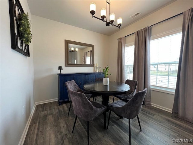 dining space featuring dark wood-type flooring, visible vents, baseboards, and a chandelier