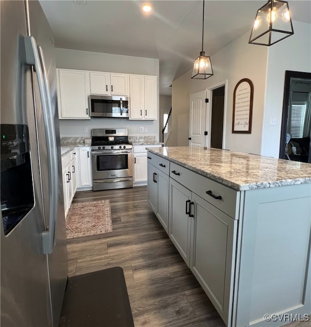 kitchen with dark wood-type flooring, a center island, stainless steel appliances, white cabinets, and light stone countertops