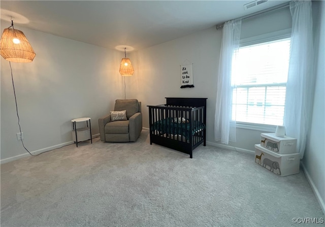 carpeted bedroom featuring a crib and baseboards