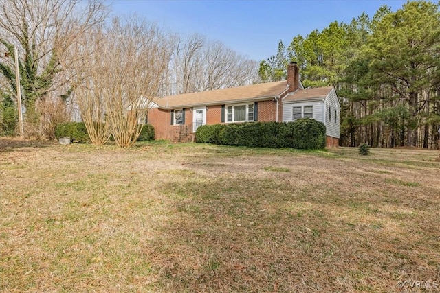 ranch-style home with a front yard, brick siding, and a chimney