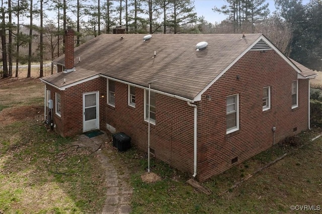 view of property exterior featuring crawl space, brick siding, and a chimney