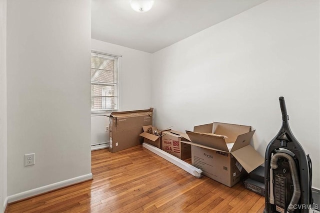 office space featuring hardwood / wood-style floors, baseboards, and a baseboard heating unit