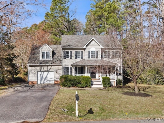 colonial inspired home with an attached garage, covered porch, a shingled roof, a front lawn, and aphalt driveway