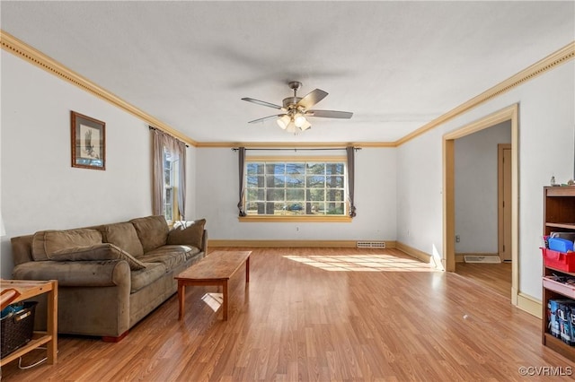 living room with visible vents, ceiling fan, light wood-style floors, and ornamental molding