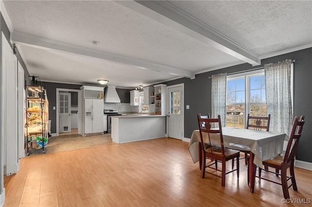 dining area featuring crown molding, baseboards, beam ceiling, light wood-style floors, and a textured ceiling