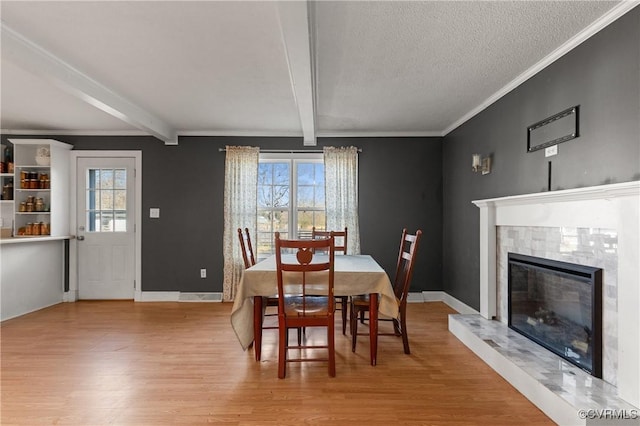 dining area featuring beamed ceiling, plenty of natural light, and wood finished floors