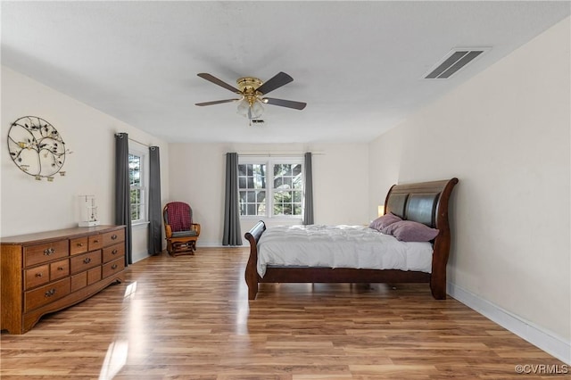 bedroom featuring visible vents, baseboards, ceiling fan, and light wood finished floors