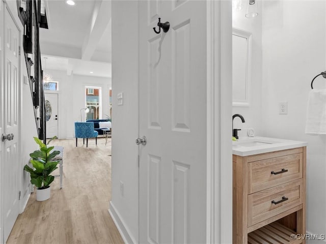 bathroom featuring recessed lighting, vanity, baseboards, and wood finished floors