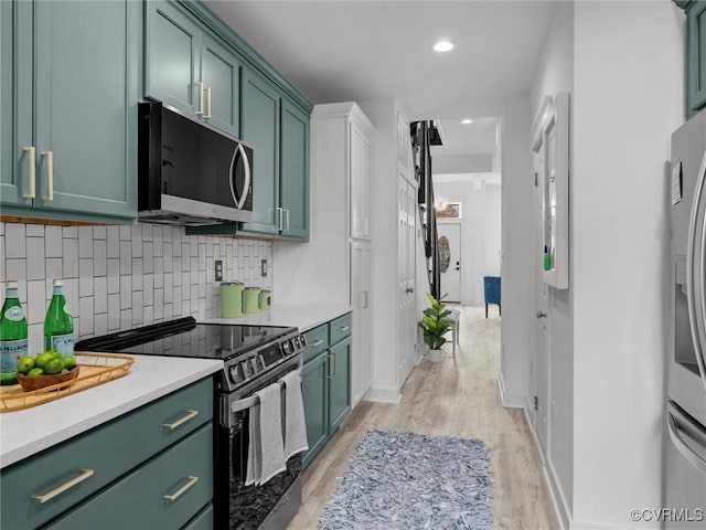 kitchen with tasteful backsplash, stainless steel appliances, light countertops, and green cabinetry