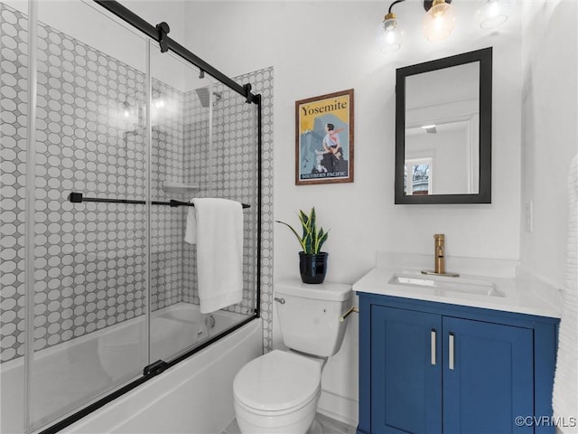 bathroom with toilet, vanity, and bath / shower combo with glass door