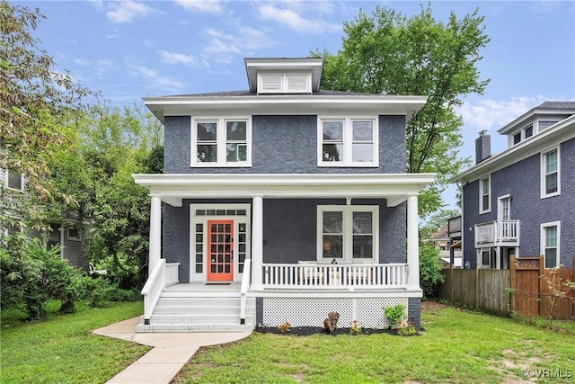 traditional style home featuring stucco siding, covered porch, a front lawn, and fence