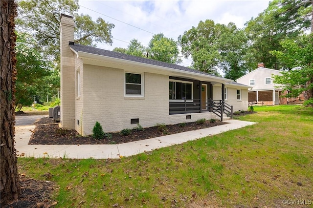 back of house with a yard, crawl space, brick siding, central AC unit, and a chimney